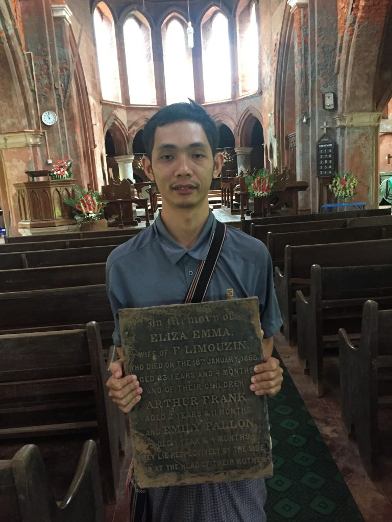 Literary Travel Priest in Moulmein holding the Limouzin gravestone.